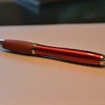 Thumbnail: A close-up of a red pen on shiny paper