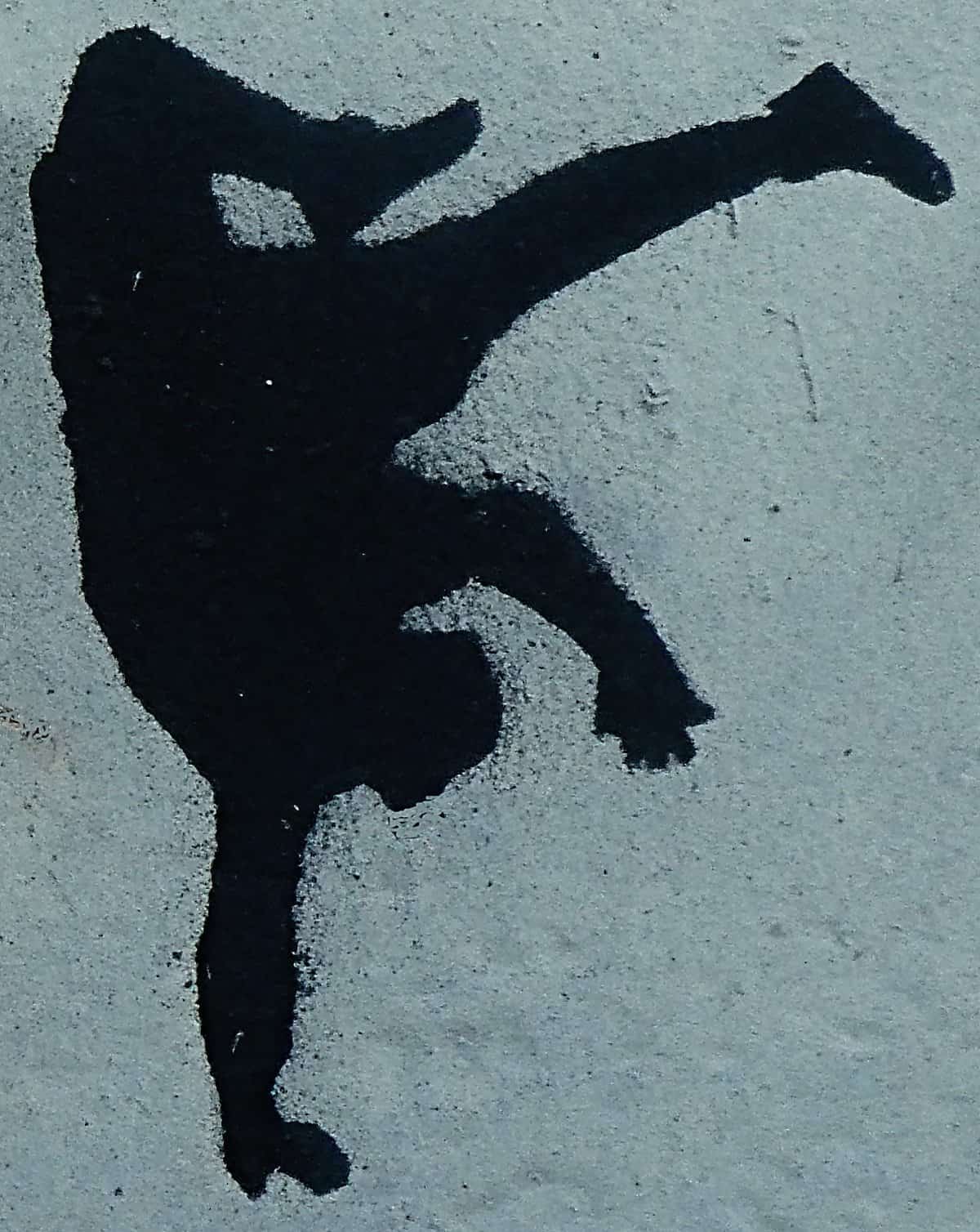 Stencil-painted image of someone somersaulting